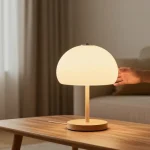 Una sala de estar tranquila con lamparas estilo japandi crema sobre una mesa de madera, creando un ambiente cálido.